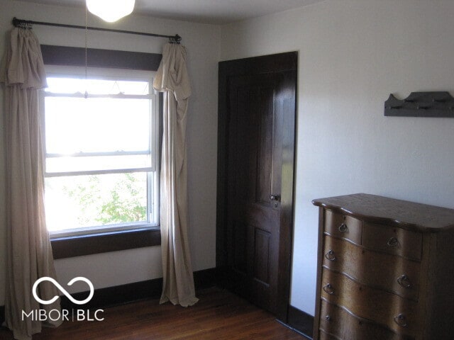 unfurnished bedroom with dark wood-type flooring