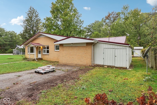 view of front of home featuring a storage unit and a front lawn