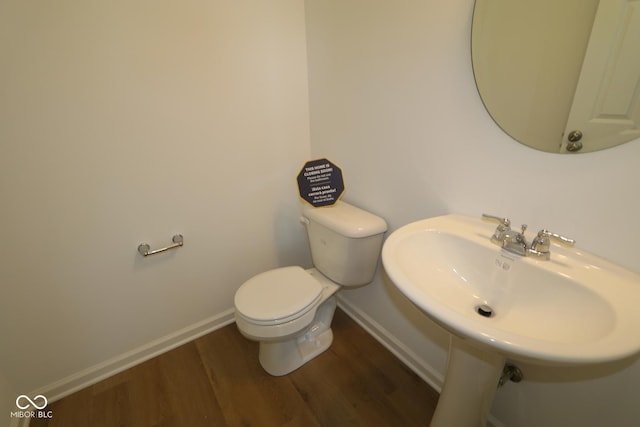 bathroom with hardwood / wood-style floors and toilet