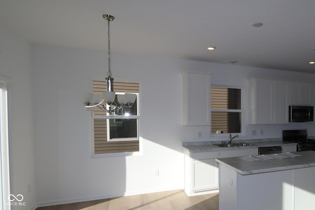 kitchen with sink, a chandelier, decorative light fixtures, white cabinets, and black appliances