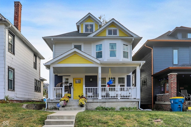 view of front of property with covered porch and a front yard