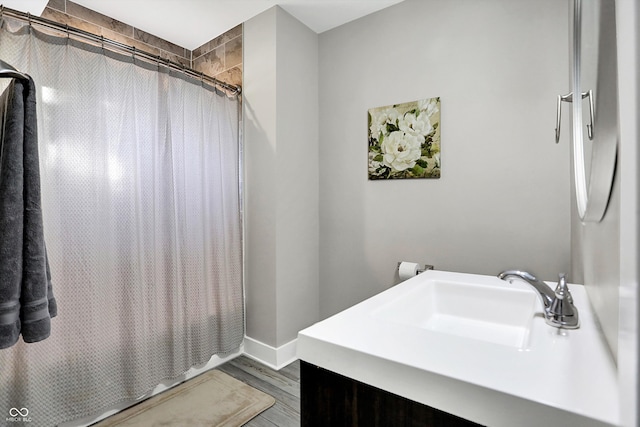 bathroom featuring wood-type flooring, walk in shower, and sink