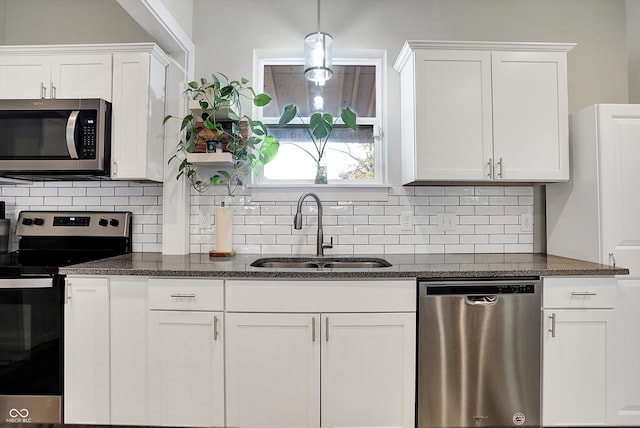 kitchen with white cabinets, decorative backsplash, sink, and stainless steel appliances