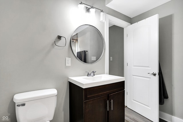 bathroom with vanity, hardwood / wood-style flooring, and toilet