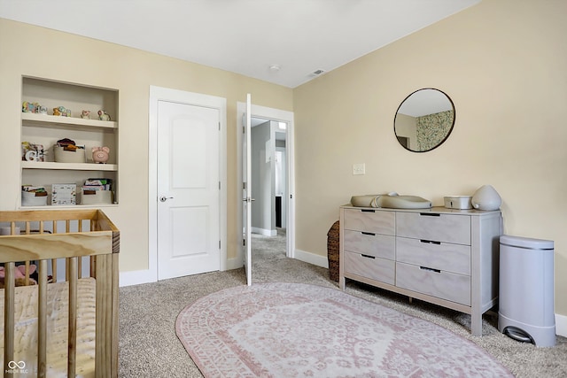 bedroom with a crib and light colored carpet