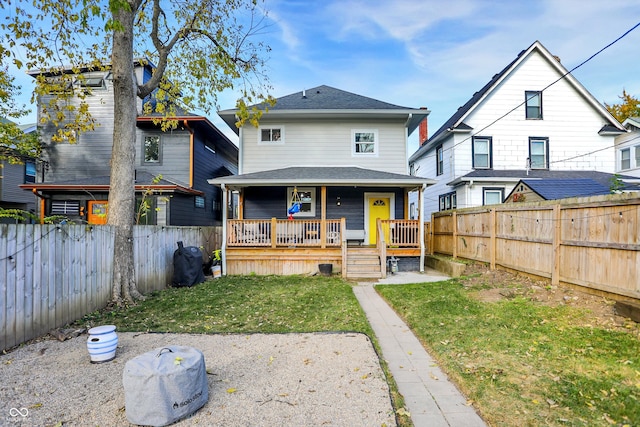 rear view of property with a lawn and a porch