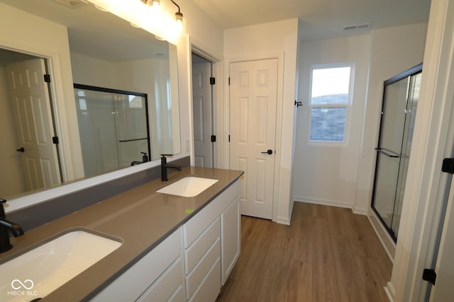 bathroom with vanity, wood-type flooring, and walk in shower