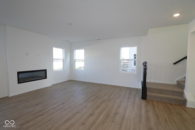 unfurnished living room with light hardwood / wood-style floors and plenty of natural light