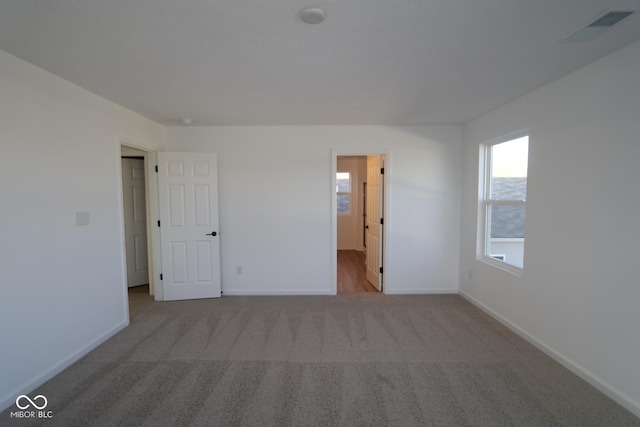 unfurnished room featuring light carpet