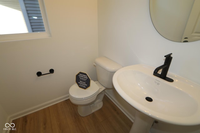 bathroom with hardwood / wood-style flooring, toilet, and sink