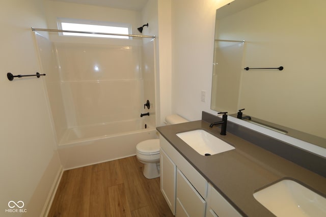 full bathroom with wood-type flooring, vanity, shower / bath combination, and toilet