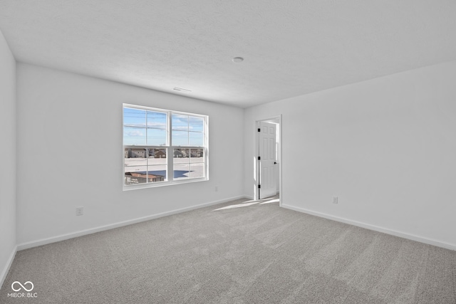 empty room with a textured ceiling and carpet