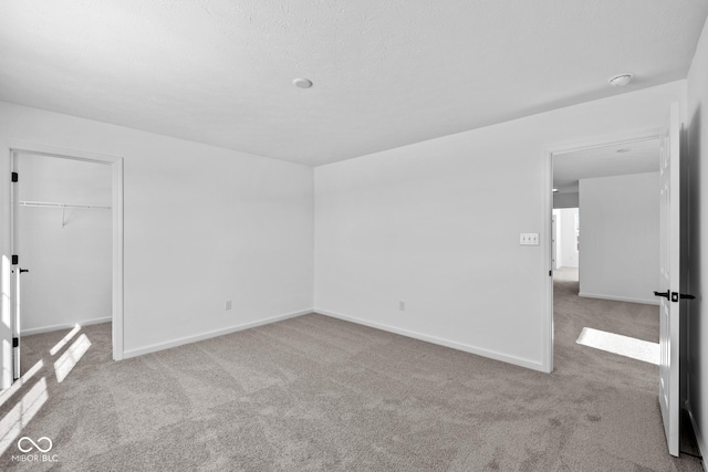 carpeted empty room with a textured ceiling