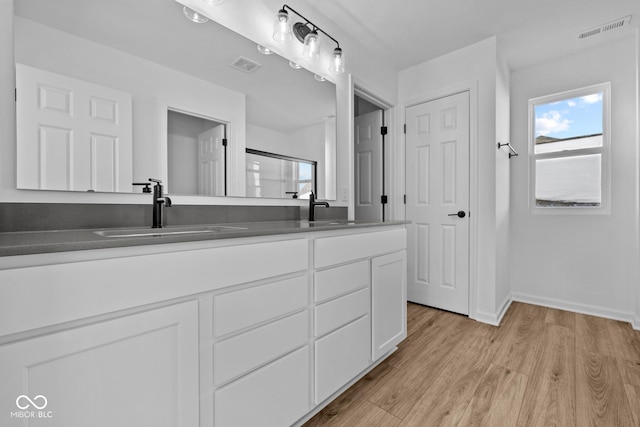 bathroom with vanity, hardwood / wood-style flooring, and walk in shower