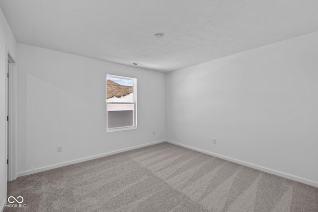 unfurnished room with carpet flooring and a textured ceiling