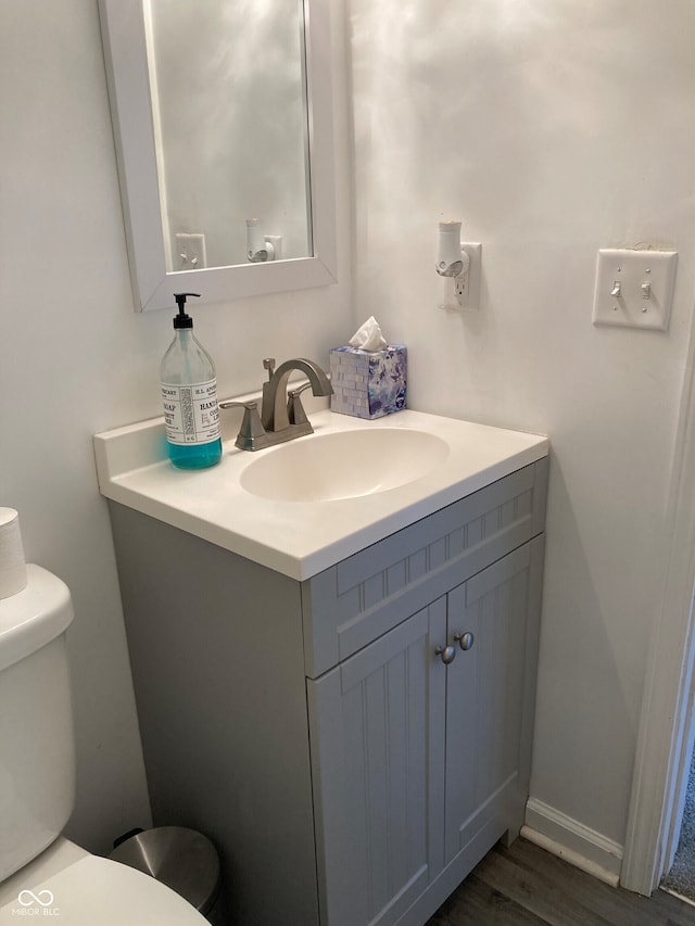 bathroom featuring vanity, toilet, and hardwood / wood-style flooring