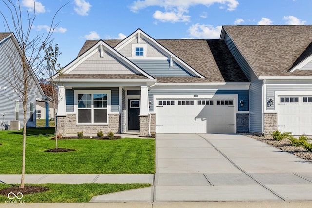 craftsman house featuring central AC unit, a garage, and a front lawn