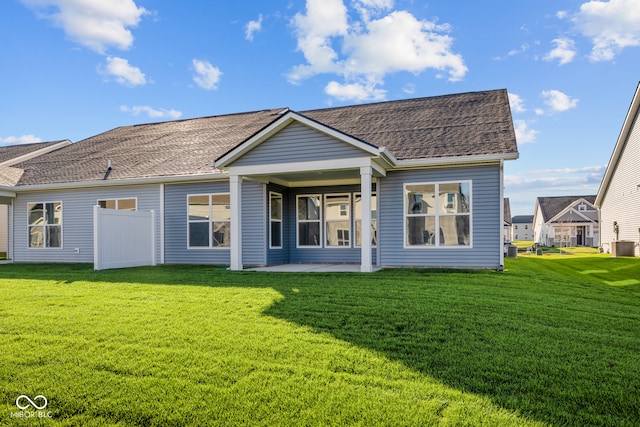 back of property with a lawn and a patio