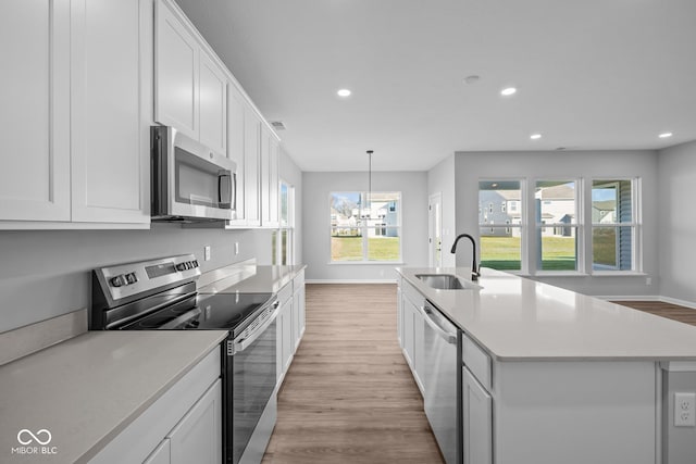 10618 Maidenhair Dr, Indianapolis, IN 46239 - kitchen with stainless steel appliances, a sink, recessed lighting, light wood-type flooring, and white cabinets