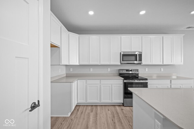 10618 Maidenhair Dr, Indianapolis, IN 46239 - kitchen featuring appliances with stainless steel finishes, light wood finished floors, white cabinetry, light countertops, and recessed lighting