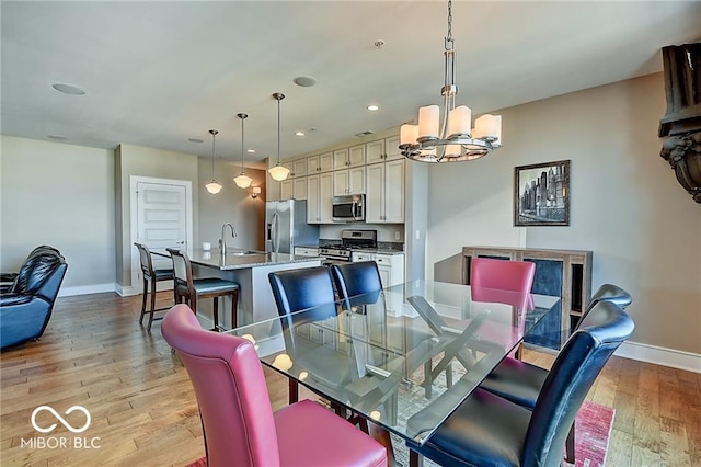 dining room featuring light hardwood / wood-style flooring, a chandelier, and sink