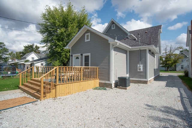 back of house with a trampoline, a deck, and central AC