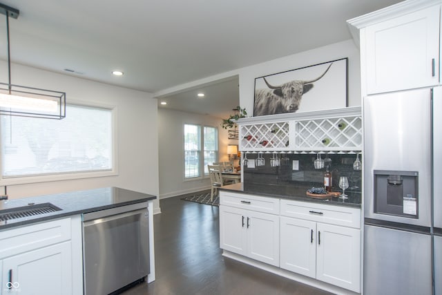 kitchen featuring sink, white cabinetry, appliances with stainless steel finishes, dark hardwood / wood-style floors, and decorative backsplash