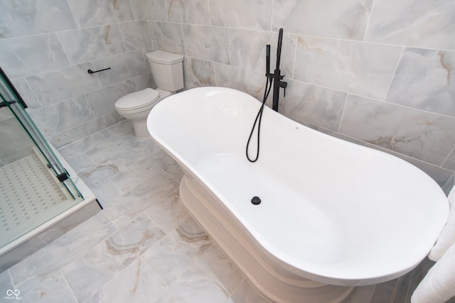 bathroom featuring independent shower and bath, tile walls, and toilet