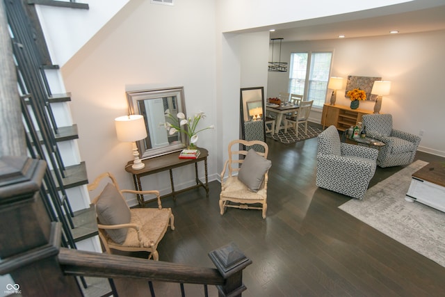 living room featuring dark wood-type flooring and a high ceiling