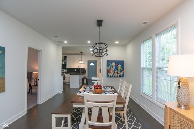 dining area with a chandelier and dark hardwood / wood-style floors