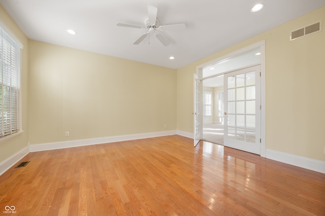 empty room featuring light wood-type flooring, ceiling fan, and french doors