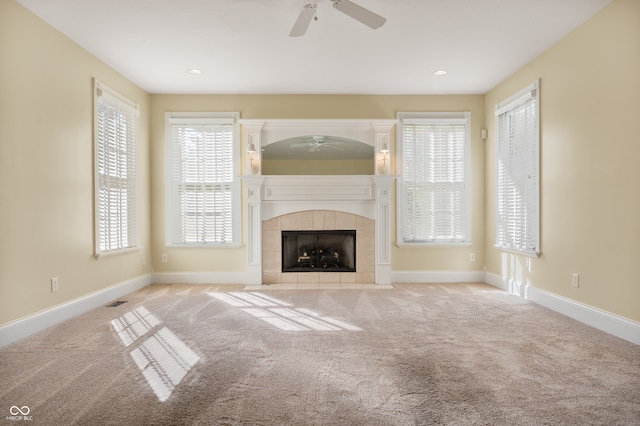 unfurnished living room with light carpet, a fireplace, and ceiling fan