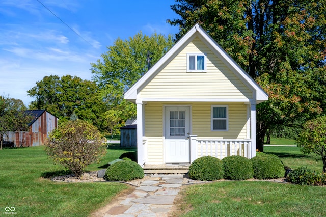 bungalow featuring an outdoor structure and a front lawn