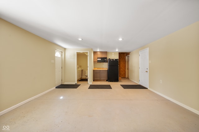 interior space with light brown cabinetry and black appliances