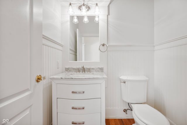 bathroom with hardwood / wood-style flooring, vanity, and toilet