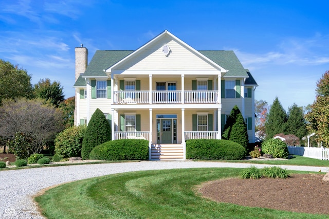 view of front of house featuring a front yard, a balcony, and a porch