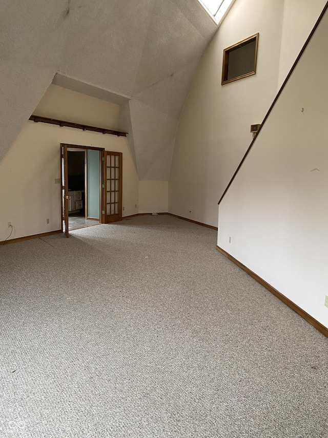 bonus room with lofted ceiling with skylight and carpet