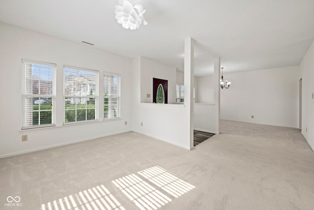 empty room with light carpet and a chandelier