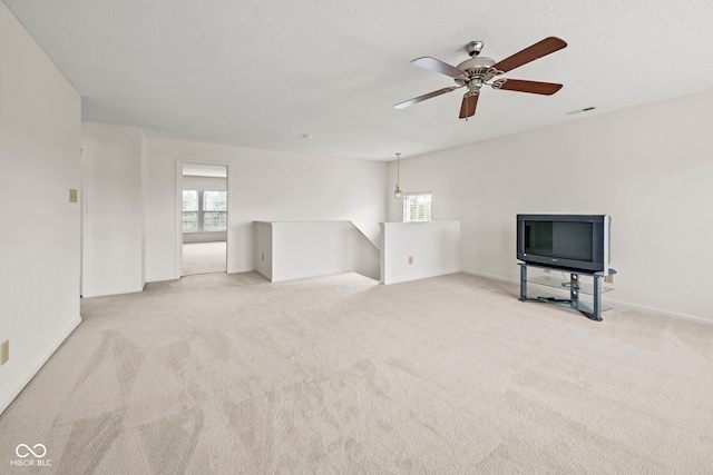 unfurnished living room featuring ceiling fan and light colored carpet