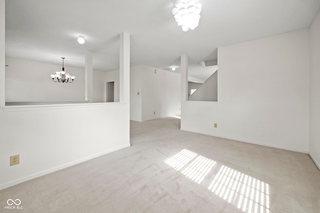 carpeted spare room with a chandelier