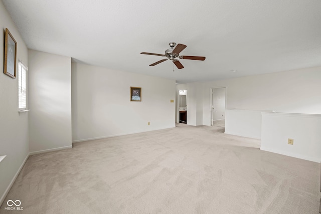 empty room featuring ceiling fan and light carpet