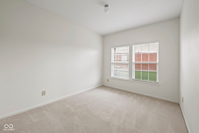 carpeted empty room with a textured ceiling