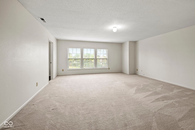 carpeted spare room with a textured ceiling