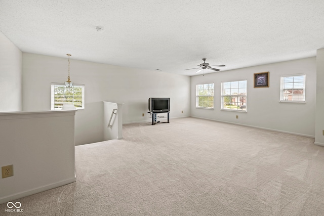 unfurnished living room featuring light carpet, a textured ceiling, and ceiling fan