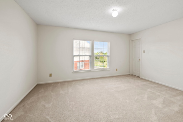 carpeted spare room featuring a textured ceiling