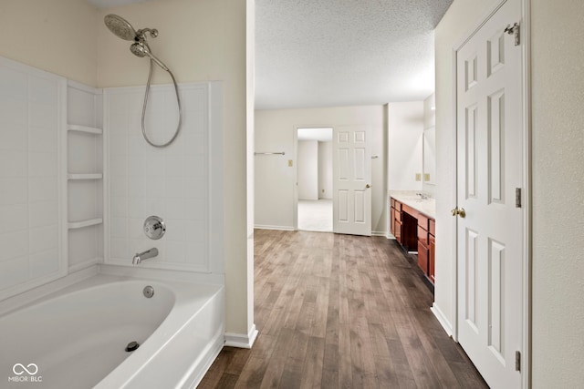 bathroom with a textured ceiling, wood-type flooring, vanity, and shower / bath combination