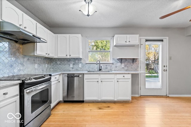 kitchen featuring a healthy amount of sunlight, white cabinets, light hardwood / wood-style floors, and appliances with stainless steel finishes