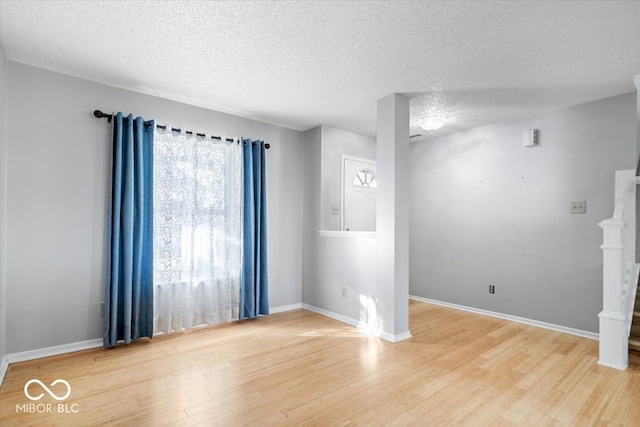 spare room featuring hardwood / wood-style floors and a textured ceiling