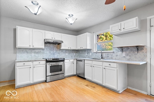 kitchen with a textured ceiling, stainless steel appliances, sink, light hardwood / wood-style flooring, and white cabinetry