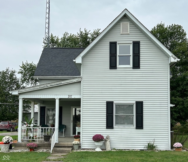 rear view of property with a yard and covered porch